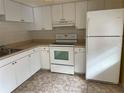 Efficient kitchen with white cabinets and appliances at 820 Virginia St # 207, Dunedin, FL 34698