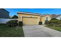 Tan house with a two-car garage and well-manicured lawn at 12425 Fairlawn Dr, Riverview, FL 33579