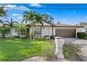 White single-story home with brown roof, palm trees, and landscaped lawn at 3401 W North B St, Tampa, FL 33609