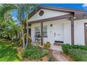 White front door with brown trim, stone path, and lush landscaping at 3401 W North B St, Tampa, FL 33609