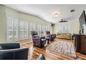 Spacious living room with hardwood floors, leather furniture, and plantation shutters at 37635 Gill Ave, Zephyrhills, FL 33541