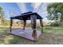 Relaxing backyard gazebo with wooden deck and curtains at 7930 Aden Loop, New Port Richey, FL 34655