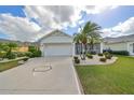 Attractive single-story home with a well-manicured lawn and a two-car garage at 1120 Emerald Dunes Dr, Sun City Center, FL 33573