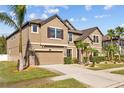 Two-story house with beige exterior, landscaping, and a three-car garage at 11818 Gilmerton Dr, Riverview, FL 33579