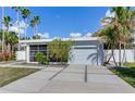 Mid-century modern home with attached garage and landscaped yard at 16434 Redington Dr, Redington Beach, FL 33708