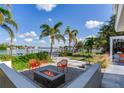 Relaxing patio with fire pit, seating, and water views at 16434 Redington Dr, Redington Beach, FL 33708