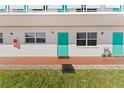 Exterior view of building showing teal doors and landscaping at 1950 59Th N Ave # 114, St Petersburg, FL 33714