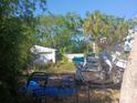 Backyard with boat, shed, and overgrown vegetation at 321 77Th Ave, St Pete Beach, FL 33706