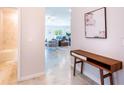 Bright and airy entryway with a modern console table, offering a view of the living room and a bathroom at 540 Rose Apple Cir, Port Charlotte, FL 33954