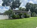 Charming one-story home with a well-maintained lawn and landscaped with decorative tropical plants and mature trees at 1003 W Mahoney St, Plant City, FL 33563