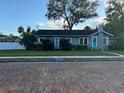Inviting single-story home featuring a classic brick road, well-manicured lawn, and a quaint turquoise door at 1003 W Mahoney St, Plant City, FL 33563