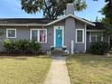 Charming home featuring a bright turquoise door, neat landscaping, and a welcoming walkway at 1003 W Mahoney St, Plant City, FL 33563