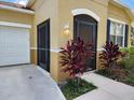 Front entrance with a screened-in porch and tropical landscaping at 107 Slipper Key Rd, Apollo Beach, FL 33572