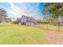 Exterior view of a two-story home with a fenced backyard and lush green lawn at 1135 Candler Rd, Clearwater, FL 33765