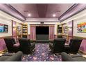 Enjoy movies in this cozy home theater with tiered seating, shelving, and ambient lighting at 2501 Rustic Oaks Dr, Lutz, FL 33559