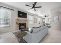 Bright living room featuring a fireplace, modern ceiling fan, and lots of natural light at 3020 Bonaventure Cir # 102, Palm Harbor, FL 34684