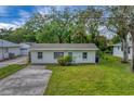 Single story home with a gray roof, white exterior and a well-maintained lawn at 4620 Violet Ave, Sarasota, FL 34233