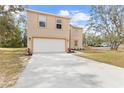 Two-story house with a white garage door and landscaping at 6489 Hazelwood Rd, Spring Hill, FL 34608