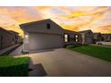 House exterior at dusk showcasing the garage and landscaping at 18027 Turning Leaf Cir, Land O Lakes, FL 34638