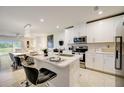 Modern kitchen with white cabinets, stainless steel appliances, and an island at 18027 Turning Leaf Cir, Land O Lakes, FL 34638