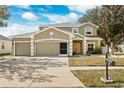 Two-story house with a three-car garage, and well-manicured lawn at 6003 Candytuft Pl, Land O Lakes, FL 34639