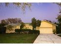 Exterior front view of a one-story home with a well-manicured lawn and attached garage at dusk at 7255 18Th Ne St, St Petersburg, FL 33702