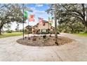 Impressive two-story home with circular driveway and multiple flags at 12709 Mannhurst Oak Ln, Lithia, FL 33547
