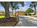 House exterior showcasing a tan garage, stone accents, and landscaping at 13141 Palmilla Cir, Dade City, FL 33525