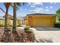 Exterior view of a house with a tan garage door and stone accents at 13141 Palmilla Cir, Dade City, FL 33525
