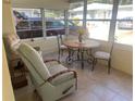 Bright and airy screened porch with seating and small table at 1601 Berwick Ct # B, Palm Harbor, FL 34684