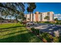 Condo building with lush landscaping and parking area at 19029 Us Highway 19 N # 9-706, Clearwater, FL 33764