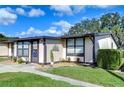 Exterior view of a light beige condo with a landscaped front yard and walkway at 37724 Alissa Dr, Zephyrhills, FL 33542