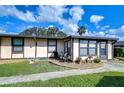 Exterior view of a light beige condo with a landscaped front yard and walkway at 37724 Alissa Dr, Zephyrhills, FL 33542