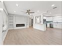 Open living room with modern electric fireplace, built-in shelving, and adjacent kitchen at 623 15Th Nw Ave, Largo, FL 33770