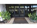 Building entrance with glass doors and landscaping at 632 Edgewater Dr # 532, Dunedin, FL 34698
