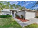 Single-story home with a well-kept front yard, two-car garage, and meticulous landscaping at 16011 Royal Aberdeen Pl, Odessa, FL 33556