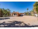 Exterior view of a waterfront home with a brick patio and lush landscaping at 1840 Venetian Point Dr, Clearwater, FL 33755