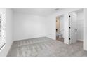 Spacious bedroom with gray carpeting and access to a bathroom at 29634 Fedora Cir, Brooksville, FL 34602
