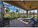 Relaxing screened patio with lounge chairs, grill, and lush tropical plants at 377 Cedar Falls Dr, Apollo Beach, FL 33572