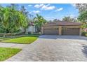 Exterior showcasing a three-car garage and paver driveway at 4907 Londonderry Dr, Tampa, FL 33647