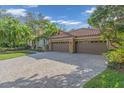 Three-car garage and paver driveway with lush landscaping at 4907 Londonderry Dr, Tampa, FL 33647