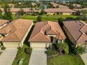 Aerial view of a well-maintained home with a clay tile roof and manicured landscaping at 5721 Sunset Falls Dr, Apollo Beach, FL 33572