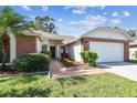 Front view of a brick house with a 2-car garage and walkway at 8910 Beeler Dr, Tampa, FL 33626