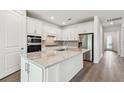 Modern kitchen showcasing white cabinetry, stainless steel appliances, and an eat-in island at 11207 Shoreline Trl, Parrish, FL 34219