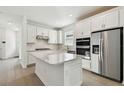 Modern kitchen with white cabinetry, stainless steel appliances, and a large center island at 9450 Shorebird Ct, Parrish, FL 34219