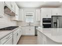 Bright kitchen featuring stainless steel appliances, white cabinets, and sleek countertops at 9450 Shorebird Ct, Parrish, FL 34219