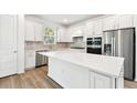 Modern kitchen with white cabinets, stainless steel appliances, and a large island at 9454 Shorebird Ct, Parrish, FL 34219