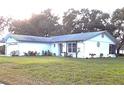 White house with blue accents, landscaping, and a two-car garage at 10621 Green Meadow Ln, Port Richey, FL 34668