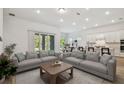 Bright, open-concept living room with modern furnishings and a view of the eat-in kitchen at 11477 Waterway Dr, Parrish, FL 34219