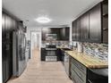 Modern kitchen featuring dark cabinetry, butcher block countertops, and stainless steel appliances at 12905 N Oregon Ave, Tampa, FL 33612